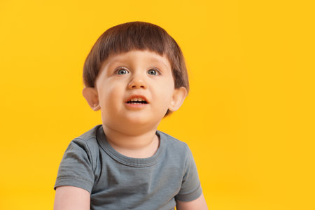 Portrait of cute little boy on yellow background. Space for textの写真素材