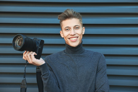 Professional photographer with camera near grey wall outdoors