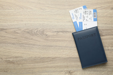 Travel agency. Flight tickets and passport on wooden table, top view. Space for textの写真素材