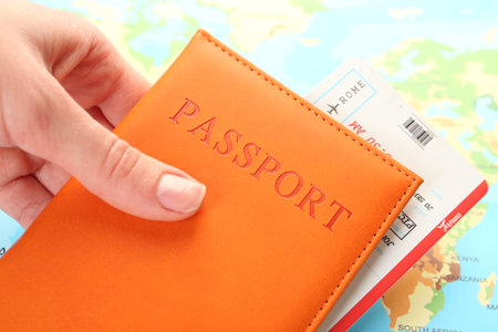 Person with passport and ticket on world map, closeupの写真素材