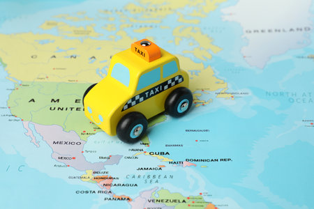Yellow taxi car on world map, closeup