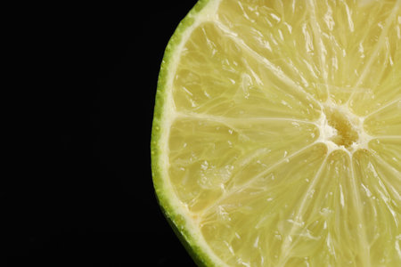 Half of fresh lime on black background, closeup. Space for textの写真素材