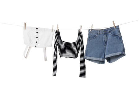Different clothes drying on laundry line against white background