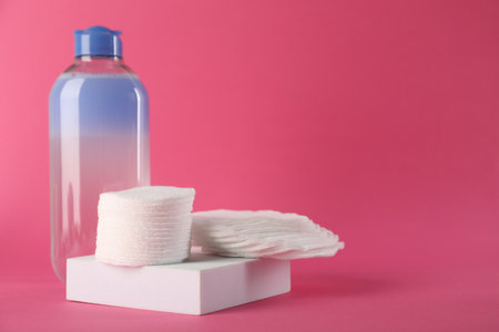 Clean cotton pads and micellar water on pink background. Space for textの写真素材
