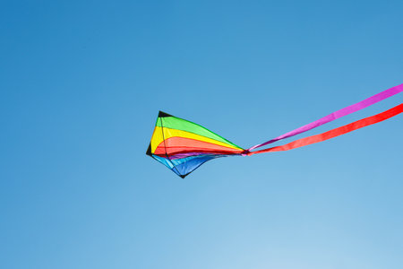One colorful kite flying in blue skyの写真素材