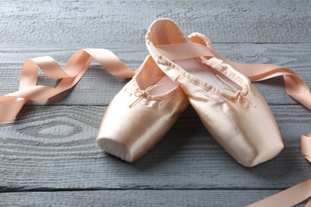 Pair of beautiful pointe shoes on gray wooden tableの写真素材
