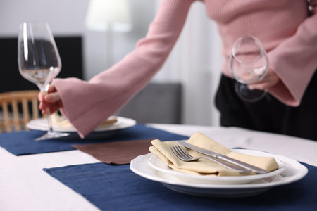 Woman setting table for dinner at home, closeupの写真素材