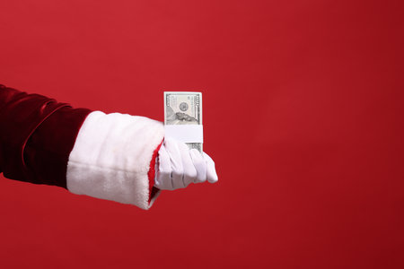 Santa Claus with dollar banknotes on red background, closeup. Space for text