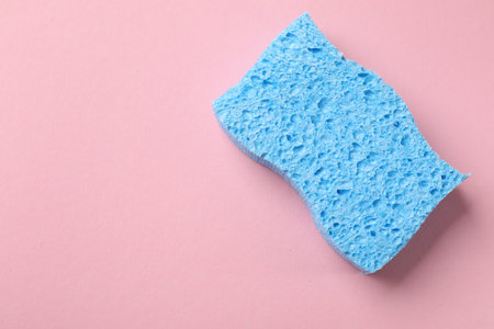 Light blue sponge on pink background, top view. Space for textの写真素材