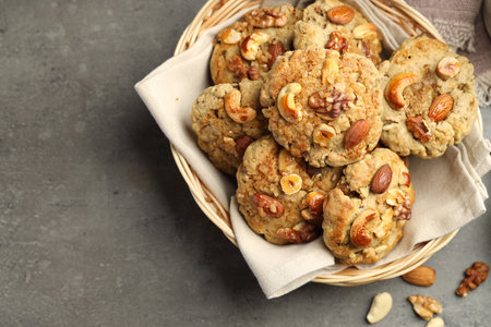 Tasty cookies with nuts in basket on grey table, top view. Space for textの写真素材