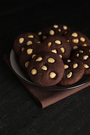 Tasty chocolate cookies with hazelnuts on black table, closeupの写真素材