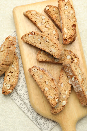 Traditional Italian almond biscuits (Cantucci) on light textured table, flat layの写真素材