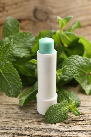 Natural lip balm and mint leaves on wooden background, closeupの写真素材