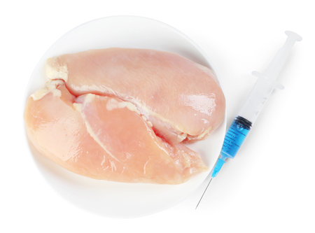 GMO concept. Chicken breasts and syringe isolated on white, top viewの写真素材