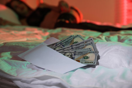 Woman in underwear on bed indoors, focus on dollar banknotesの写真素材