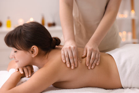 Young woman receiving massage in spa salonの写真素材