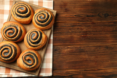 Tasty buns with poppy seeds on wooden table, top view. Space for textの写真素材