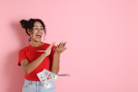 Happy woman throwing money on pink background, space for textの写真素材