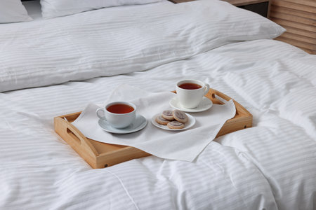 Breakfast tray on bed with beautiful linens indoorsの写真素材