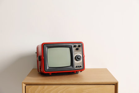 Retro tv set on nightstand against white wallの写真素材