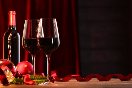 Red wine and Christmas decor on wooden table. Space for textの写真素材