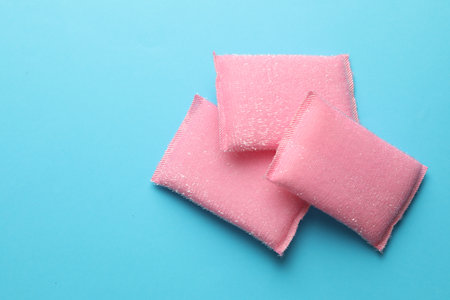 Pink sponges on light blue background, top view. Space for textの写真素材