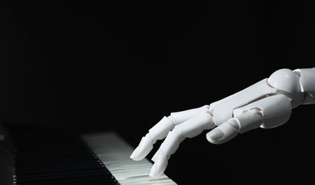 Artificial intelligence. Robot hand playing piano on black background, closeupの写真素材