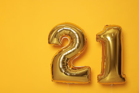Coming of age party - 21st birthday. Number shaped balloons on orange backgroundの写真素材