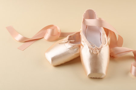 Pair of beautiful pointe shoes on beige backgroundの写真素材