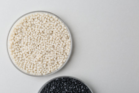 Colorful plastic granules in petri dishes on gray background, flat lay.の写真素材