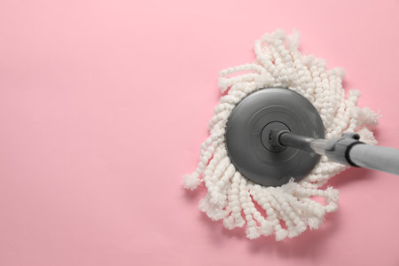 Mop with metal handle on pink background, top view. Space for textの写真素材