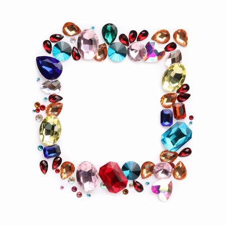Frame of different shiny gemstones on white background, flat lay. Space for textの写真素材