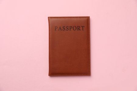 Passport in brown cover on pink background, top viewの写真素材