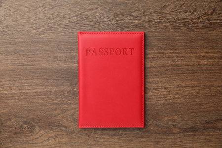 Passport in red cover on wooden table, top viewの写真素材