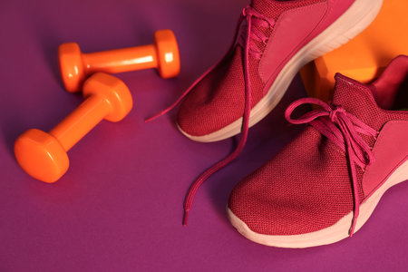 Stylish sneakers, dumbbells and yoga block on bright background, closeupの写真素材
