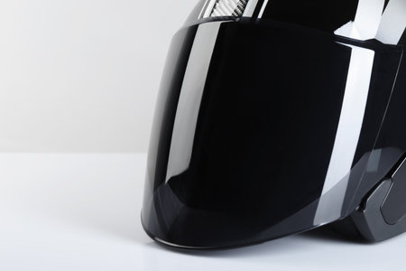 Modern motorcycle helmet with visor on light background, closeup. Space for textの写真素材