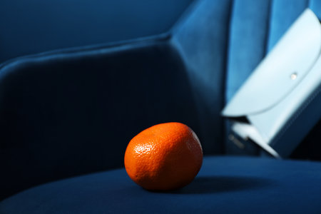 Fresh ripe tangerine on dark blue armchairの写真素材