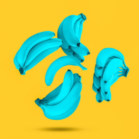 Blue bananas in air on yellow backgroundの写真素材