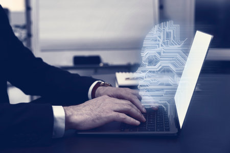 Businessman working on laptop at desk, closeup. Digital head coming out of computer symbolizing artificial intelligenceの写真素材