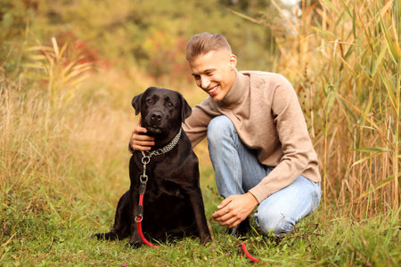 Smiling man with cute dog outdoors on autumn dayの写真素材