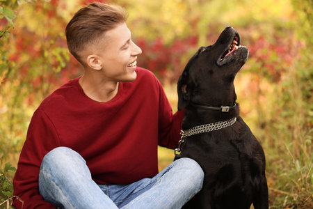 Smiling man with cute dog outdoors on autumn dayの写真素材
