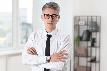 Portrait of businessman with crossed arms in officeの写真素材