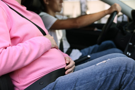 Pregnant woman travelling with her husband by car, closeupの写真素材