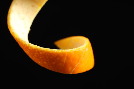 One curly orange peel on black background, closeupの写真素材