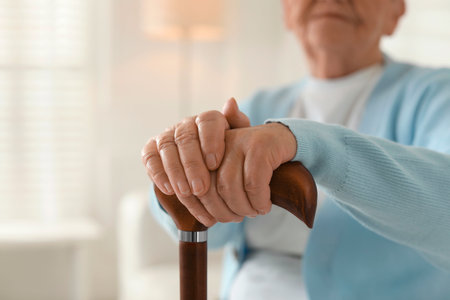 Lonely senior woman with walking cane indoors, closeup. Space for textの写真素材