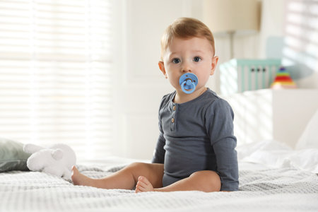 Cute little baby on bed at homeの写真素材