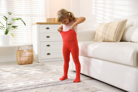 Little girl putting on soft tights at homeの写真素材