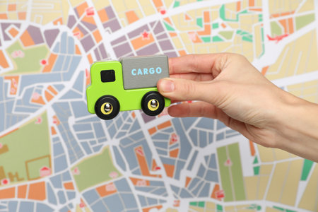 Woman with toy truck against city map, closeup.の写真素材