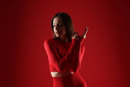 Woman in stylish sportswear on red backgroundの写真素材