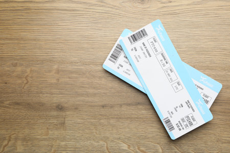 Travel agency. Flight tickets on wooden table, top view. Space for text